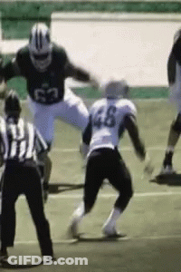 A Football Player With The Number 46 On His Jersey Is Being Tackled GIF