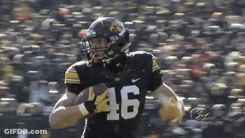 A Football Player With The Number 46 On His Jersey Is Running With The Ball . GIF