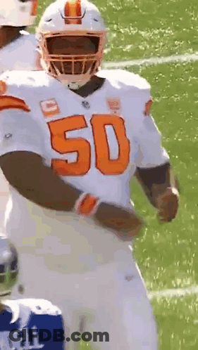 A Football Player With The Number 50 On His Jersey Is Standing On The Field . GIF