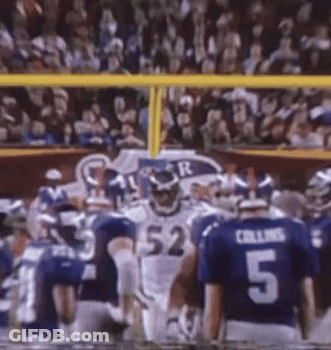 A Football Player With The Number 52 On His Jersey Stands In Front Of A Crowd GIF