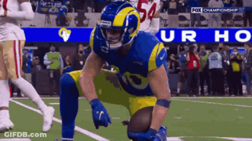 A Football Player With The Number 54 On His Helmet Kneeling On The Field GIF