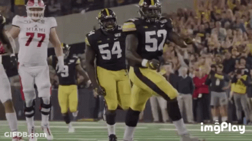 A Football Player With The Number 54 On His Jersey Is Running With The Ball GIF