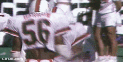 A Football Player With The Number 56 On His Jersey Is Running On A Field . GIF