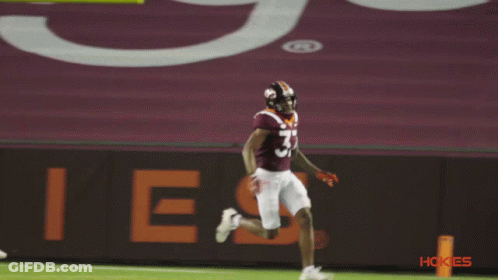 A Football Player With The Number 57 On His Jersey Is Running On The Field GIF