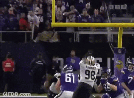 A Football Player With The Number 61 On His Jersey Is Being Tackled By Another Player GIF