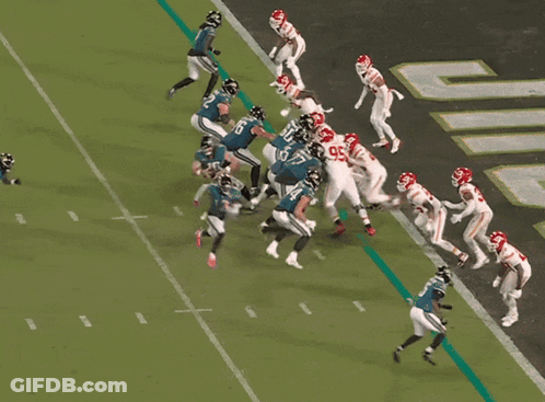 A Football Player With The Number 65 On His Jersey Is Being Tackled By Another Player GIF