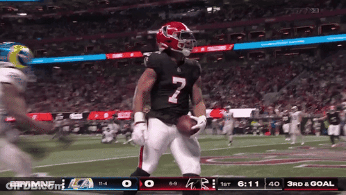 A Football Player With The Number 7 On His Jersey Is Holding A Football GIF