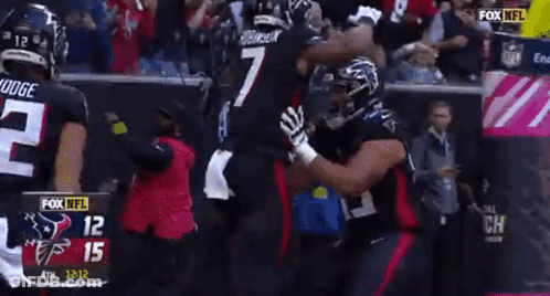 A Football Player With The Number 7 On His Jersey Is Hugging Another Player GIF