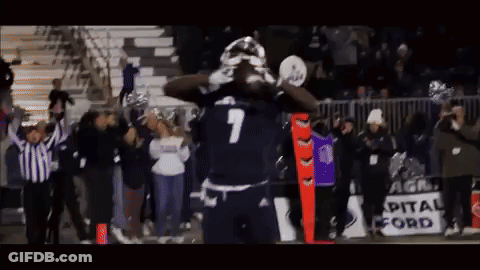 A Football Player With The Number 7 On His Jersey Stands In Front Of A Crowd GIF