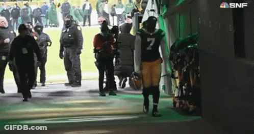 A Football Player With The Number 7 On His Jersey Walks Out Of A Locker Room GIF