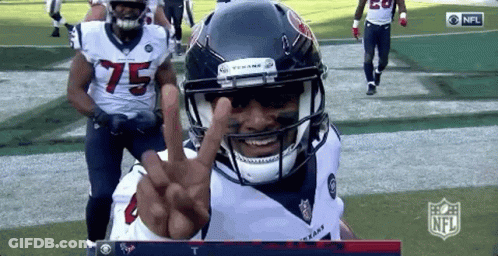 A Football Player With The Number 75 On His Jersey Is Giving A Peace Sign GIF