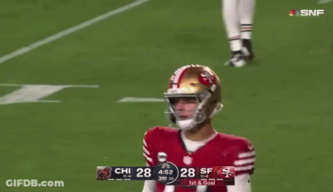 A Football Player With The Number 77 On His Jersey Stands Next To A Player With The Number 14 On His Jersey GIF