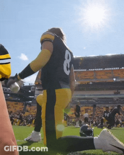 A Football Player With The Number 8 On His Back Is Kneeling On The Field GIF
