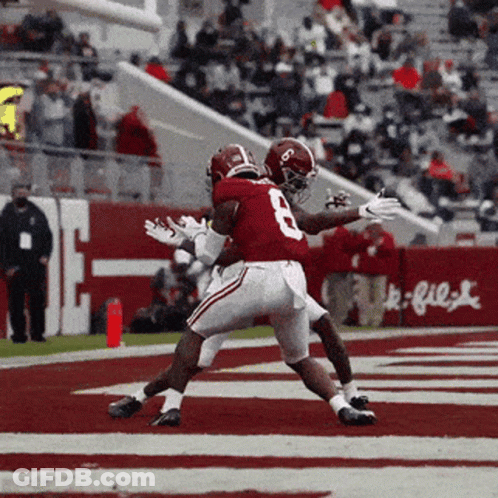 A Football Player With The Number 8 On His Jersey Is Being Tackled By Another Player GIF