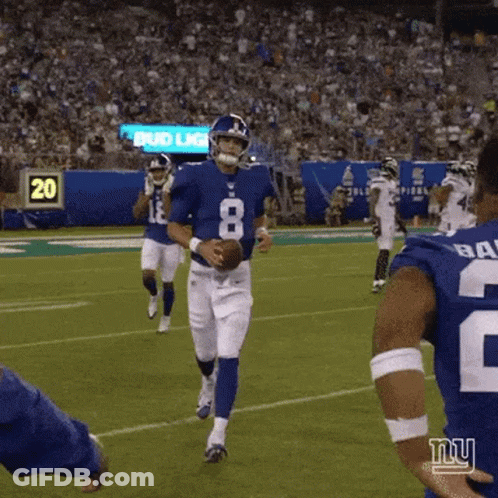 A Football Player With The Number 8 On His Jersey Is Holding A Ball On A Field . GIF