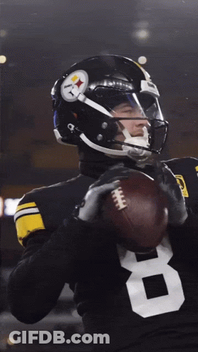 A Football Player With The Number 8 On His Jersey Is Holding A Football GIF