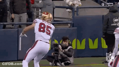 A Football Player With The Number 85 On His Back Is Standing On A Field . GIF