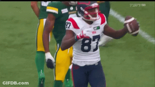 A Football Player With The Number 87 On His Jersey Holds A Football In His Hand GIF