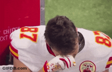A Football Player With The Number 87 On His Jersey Wipes His Face GIF