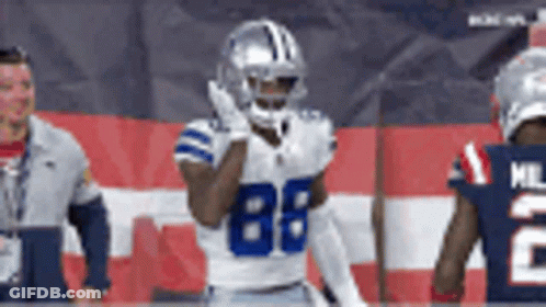 A Football Player With The Number 88 On His Jersey Stands In Front Of A Flag . GIF