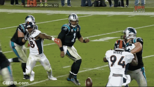 A Football Player With The Number 94 On His Jersey Is Being Tackled GIF