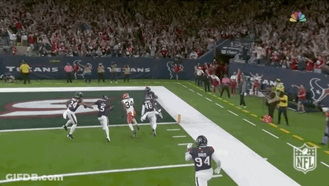A Football Player With The Number 94 On His Jersey Is Running On The Field During A Game . GIF