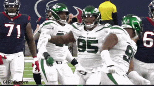 A Football Player With The Number 95 On His Jersey Is Being Hugged By His Teammates GIF