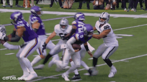 A Football Player With The Number 98 On His Jersey Is Being Tackled By A Vikings Player GIF