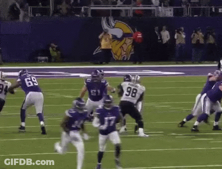A Football Player With The Number 98 On His Jersey Is Running On The Field GIF