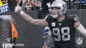 A Football Player With The Number 98 On His Jersey Stands In Front Of A Crowd GIF