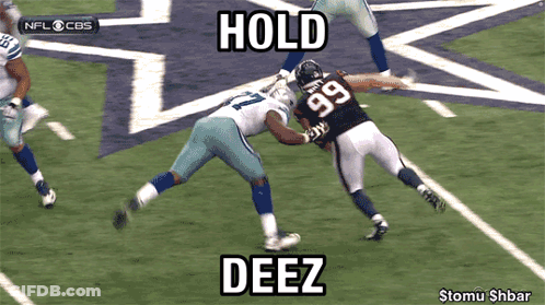 A Football Player With The Number 99 On His Jersey Is Being Tackled GIF