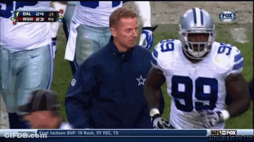 A Football Player With The Number 99 On His Jersey Stands Next To A Coach GIF