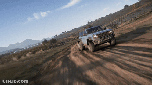 A Ford Bronco Is Driving Down A Dirt Road GIF