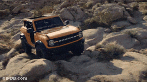 A Ford Bronco Is Driving On A Rocky Road GIF