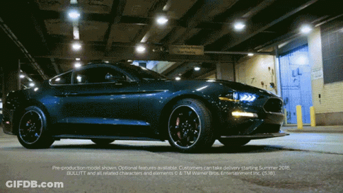 A Ford Mustang Is Parked In Front Of A Warehouse GIF