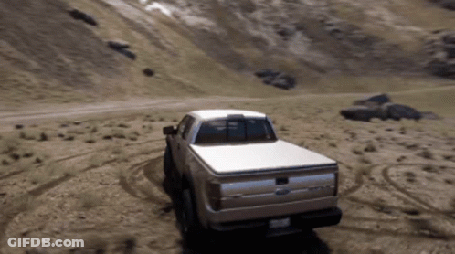 A Ford Truck Driving Down A Dirt Road GIF