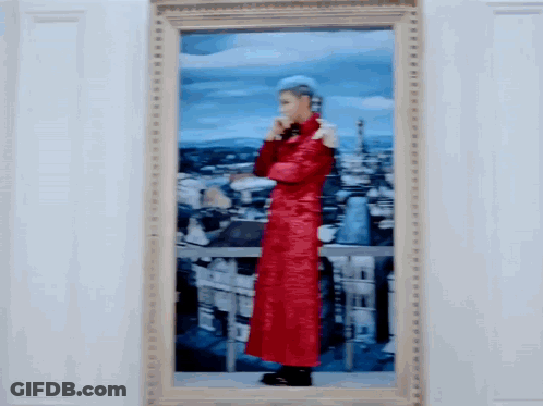 A Framed Painting Of A Man In A Red Coat Standing In Front Of A City GIF