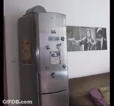 A Fridge With A Picture Of Pulp Fiction On The Wall Behind It GIF