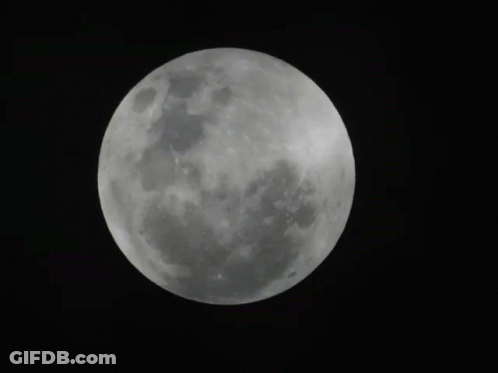 A Full Moon Is Visible In The Dark Sky GIF