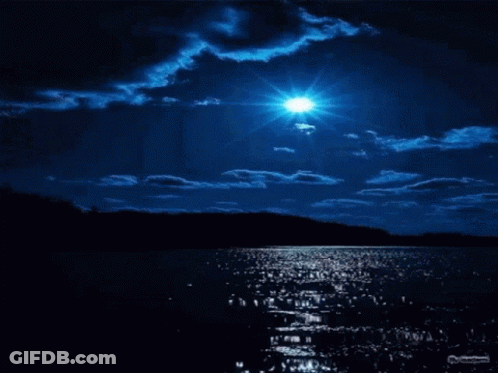 A Full Moon Shines Brightly Over A Lake At Night GIF