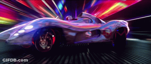 A Futuristic Car Is Driving Down A Street With A Rainbow Of Lights Behind It GIF
