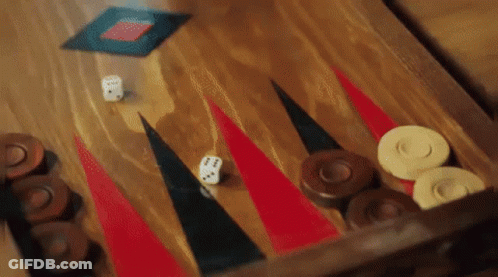 A Game Of Backgammon Is Being Played On A Wooden Board . GIF