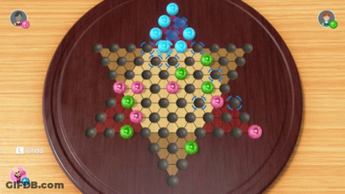 A Game Of Chinese Checkers Is On A Wooden Board GIF