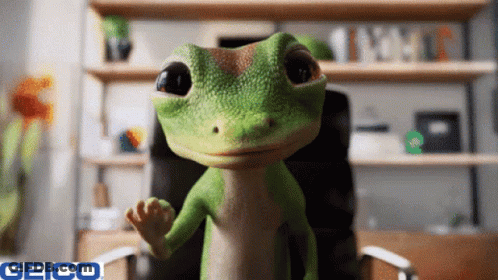 A Geico Ad With A Lizard In An Office Chair GIF