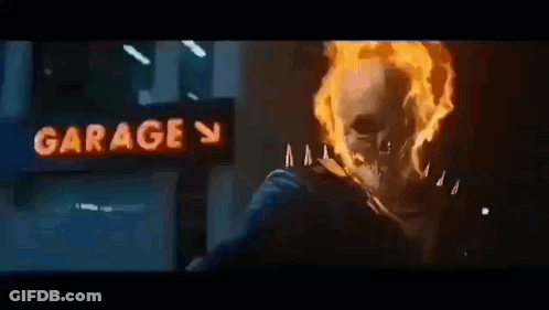 A Ghost Rider Is Riding A Motorcycle In Front Of A Garage . GIF