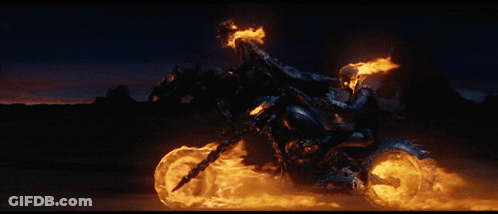 A Ghost Rider Is Riding A Motorcycle With Flames On The Wheels GIF