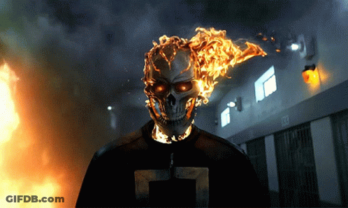 A Ghost Rider With Flames Coming Out Of His Head Is Standing In Front Of A Building With A Sign That Says Exit GIF