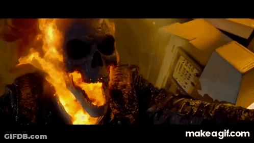 A Ghost Rider With Flames Coming Out Of His Mouth Is Standing Next To A Box GIF
