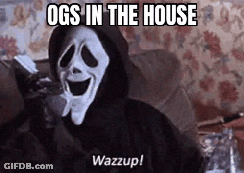 A Ghostface From The Movie Scream Is Sitting On A Couch Holding A Remote Control . GIF