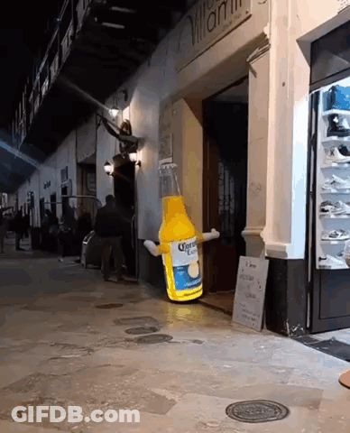 A Giant Bottle Of Corona Beer Is Sitting Outside Of A Store GIF